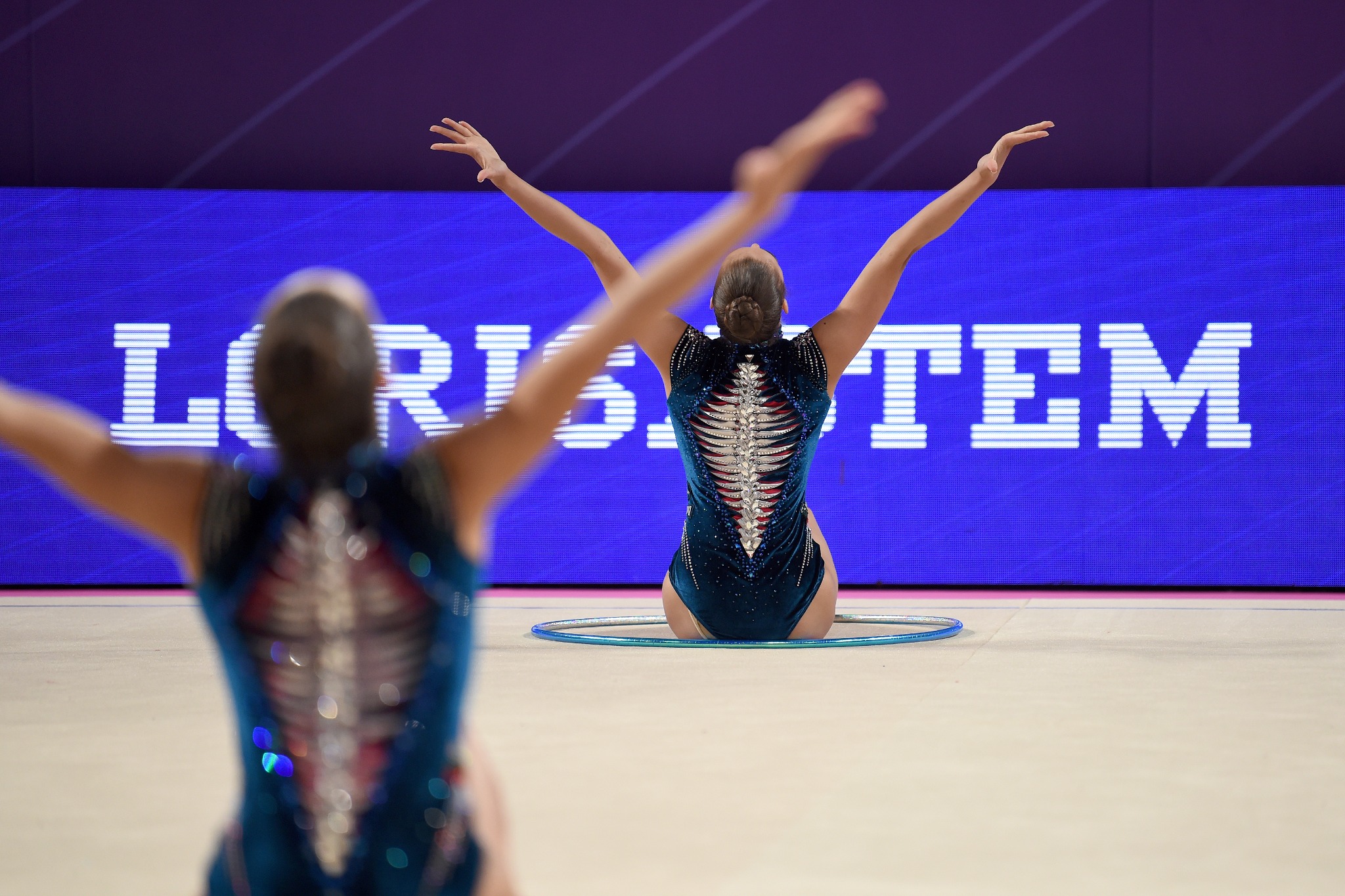 Ginnaste davanti al display con il marchio Lorisystem
